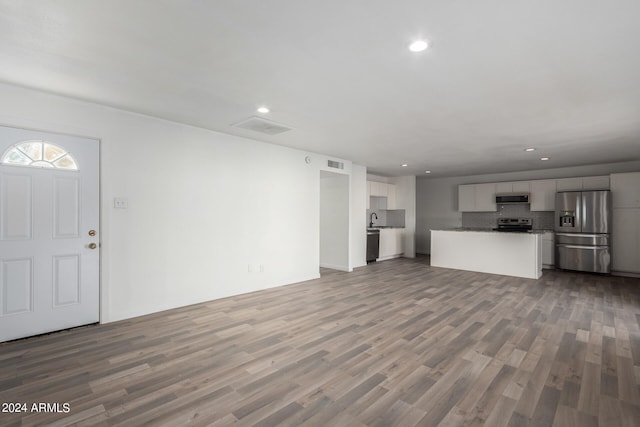 unfurnished living room featuring sink and hardwood / wood-style floors