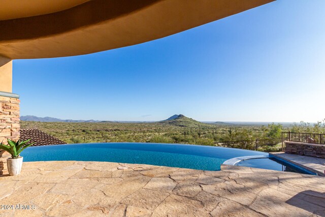 view of swimming pool featuring a mountain view and a patio area