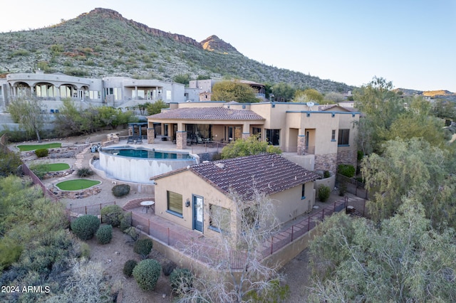 rear view of property featuring a patio, a fenced in pool, and a mountain view