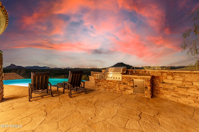 patio terrace at dusk with grilling area and exterior kitchen