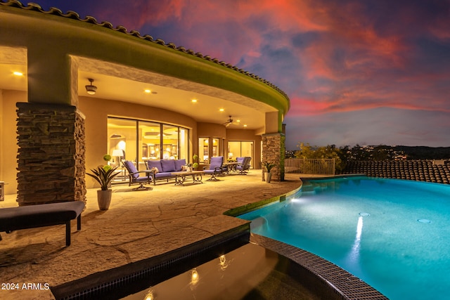 pool at dusk featuring outdoor lounge area and a patio