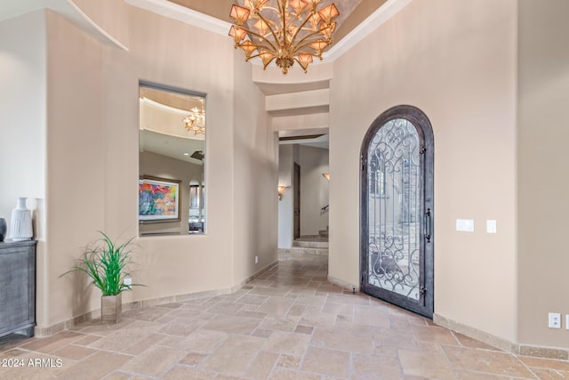 tiled entryway featuring a notable chandelier and a towering ceiling