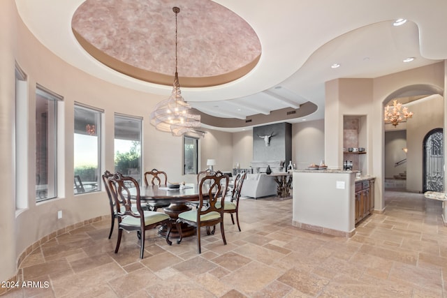 dining space with a chandelier, a tray ceiling, and light tile flooring