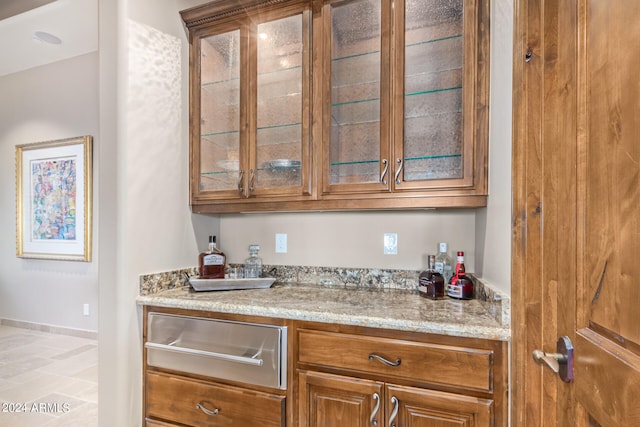 kitchen featuring light tile floors and light stone counters