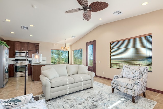 tiled living room with vaulted ceiling and ceiling fan with notable chandelier