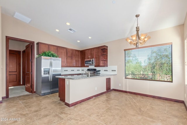 kitchen with kitchen peninsula, a notable chandelier, stainless steel appliances, light tile floors, and vaulted ceiling