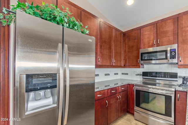 kitchen with backsplash, light stone countertops, light tile floors, and appliances with stainless steel finishes