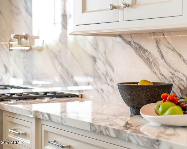 details featuring light stone countertops and cream cabinetry