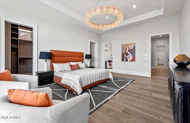 bedroom featuring hardwood / wood-style flooring and a tray ceiling