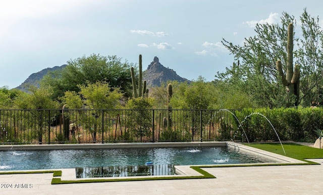 view of swimming pool with a patio, a mountain view, and pool water feature