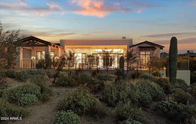 view of back house at dusk