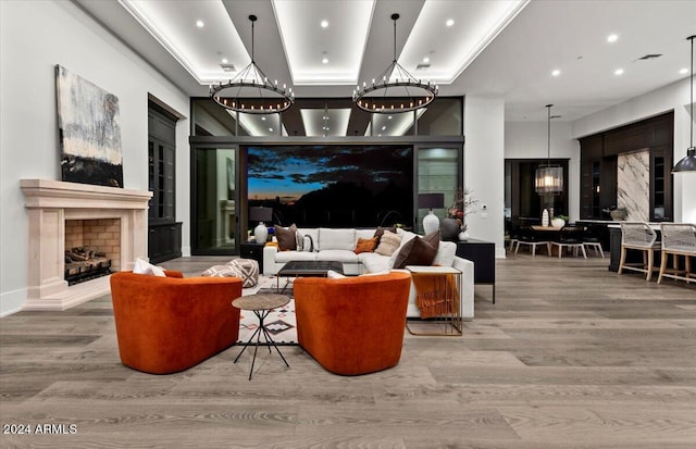 interior space with a raised ceiling, wood-type flooring, and a high end fireplace