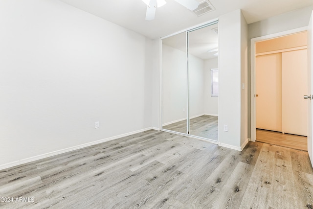 unfurnished bedroom with a closet, light wood-type flooring, and ceiling fan