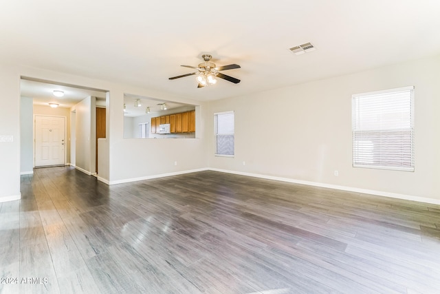 unfurnished living room featuring ceiling fan and dark hardwood / wood-style flooring