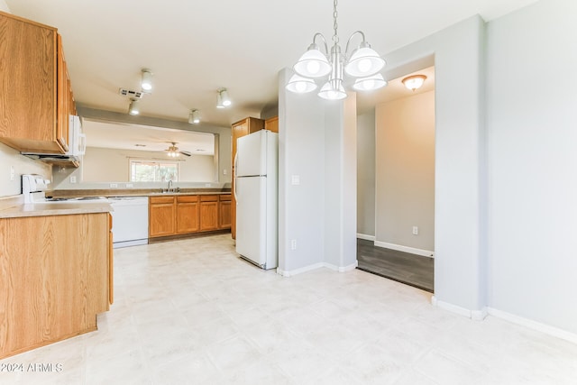 kitchen with a chandelier, sink, pendant lighting, and white appliances