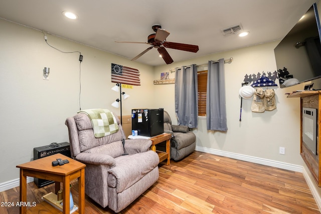 sitting room with ceiling fan and light wood-type flooring