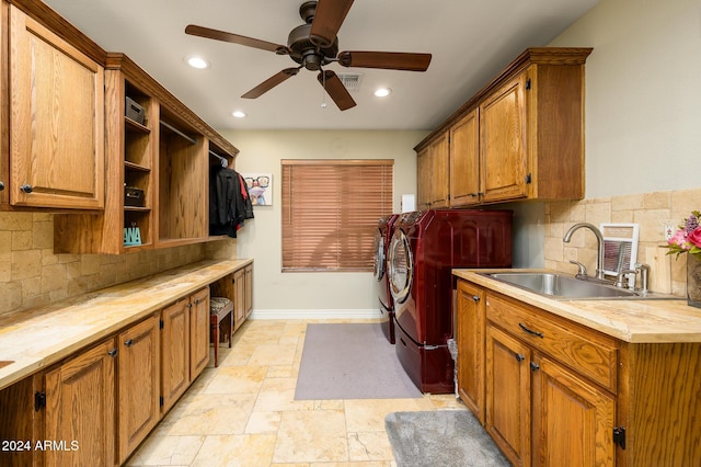 clothes washing area with ceiling fan, cabinets, sink, and washing machine and clothes dryer