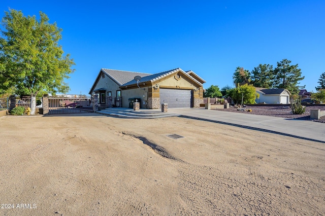 5701 N 105th Ln, Glendale, AZ 85307 - ranch-style house with stone siding, an attached garage, concrete driveway, and a gate