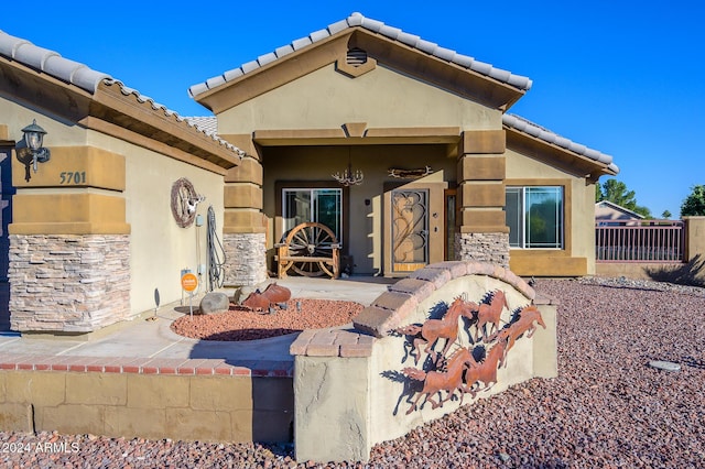 5701 N 105th Ln, Glendale, AZ 85307 - doorway to property with stucco siding, a tiled roof, and stone siding