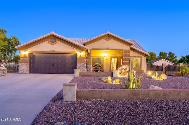 5701 N 105th Ln, Glendale, AZ 85307 - view of front of home with driveway, stucco siding, an attached garage, stone siding, and a tiled roof