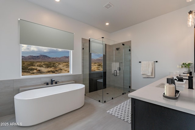 bathroom featuring a freestanding tub, vanity, visible vents, tile walls, and a stall shower