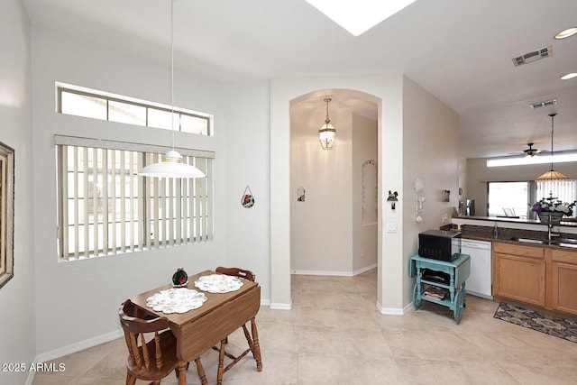 dining room with a ceiling fan, visible vents, arched walkways, and baseboards