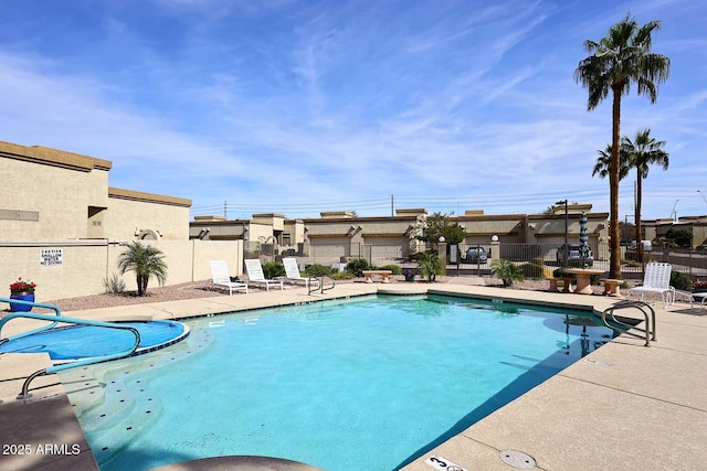 pool with a patio area and fence