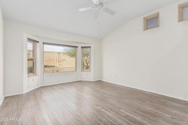 empty room with vaulted ceiling, ceiling fan, and hardwood / wood-style floors