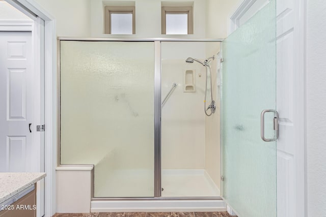 bathroom with a shower with shower door and vanity