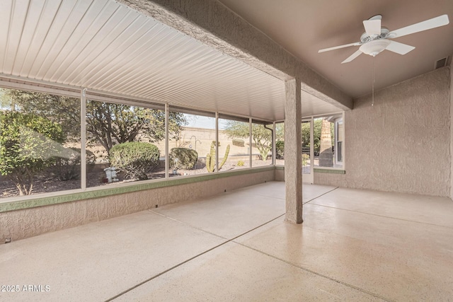 unfurnished sunroom featuring ceiling fan