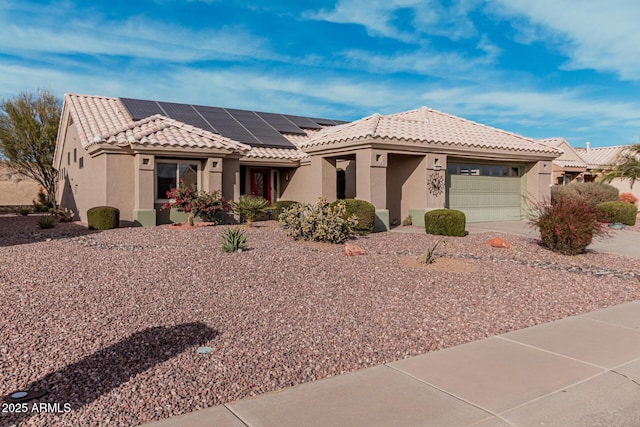 view of front facade with a garage and solar panels