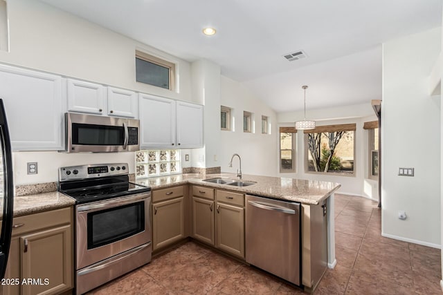 kitchen with appliances with stainless steel finishes, sink, decorative light fixtures, kitchen peninsula, and vaulted ceiling