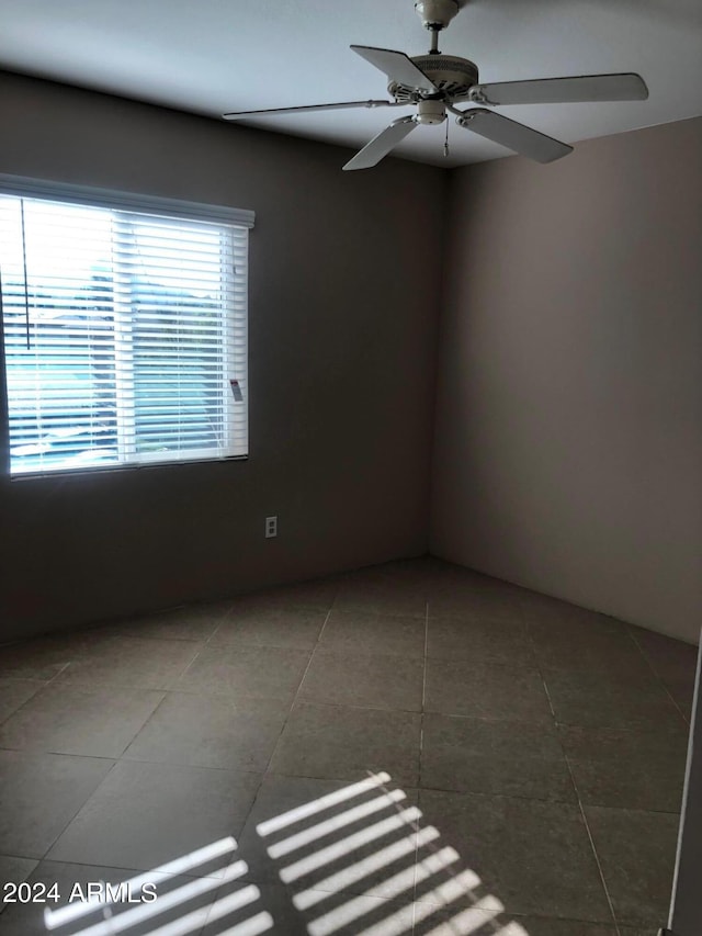 unfurnished room with ceiling fan and tile patterned flooring