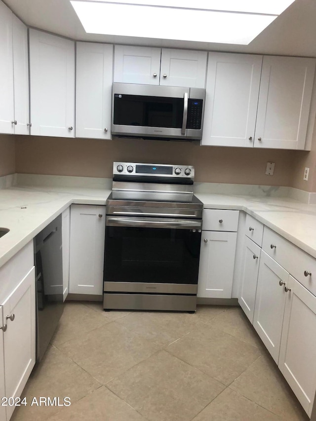 kitchen with white cabinetry, light tile patterned floors, and appliances with stainless steel finishes