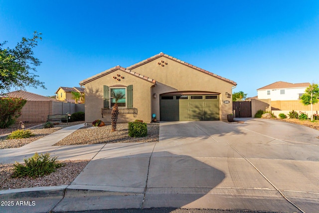 mediterranean / spanish house featuring stucco siding, driveway, and fence