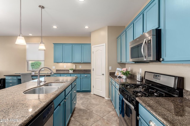 kitchen with appliances with stainless steel finishes, a sink, blue cabinetry, light tile patterned floors, and recessed lighting