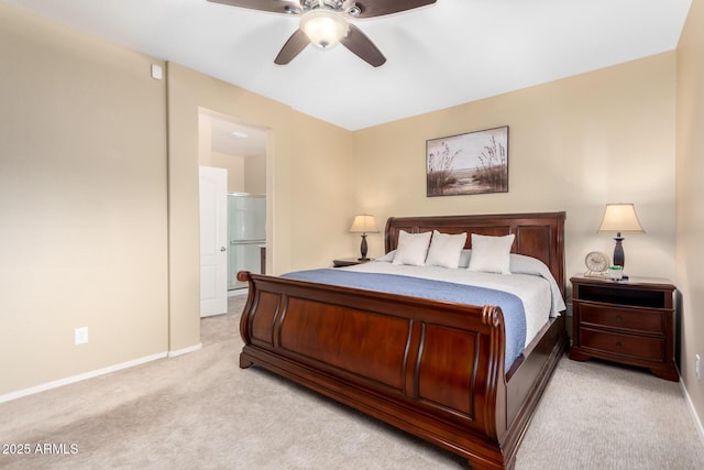 bedroom featuring light carpet, baseboards, ensuite bath, and a ceiling fan