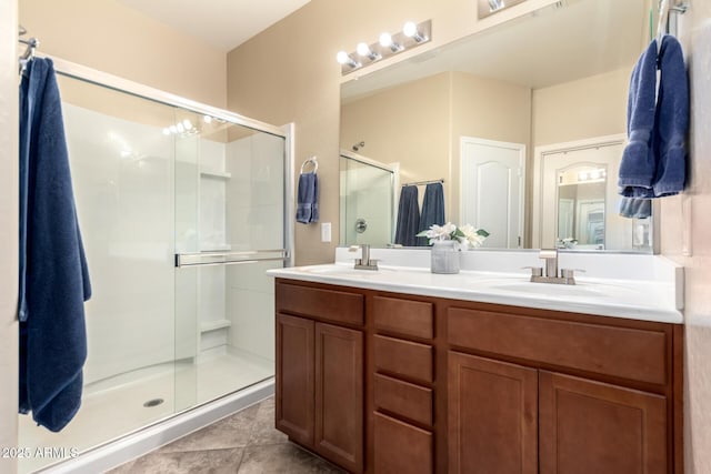 bathroom featuring a stall shower, double vanity, and tile patterned flooring
