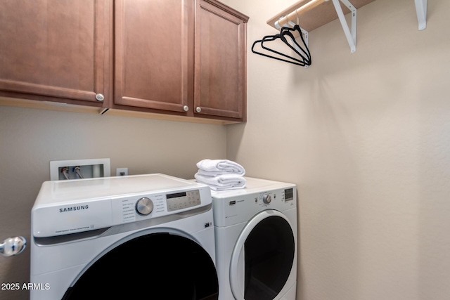laundry area featuring washer and clothes dryer and cabinet space