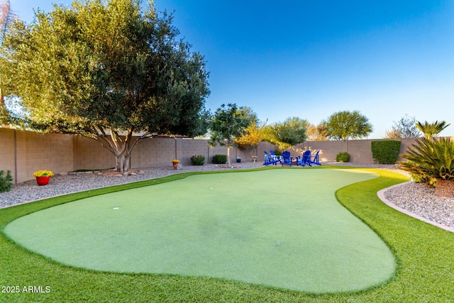 fenced backyard with a putting green