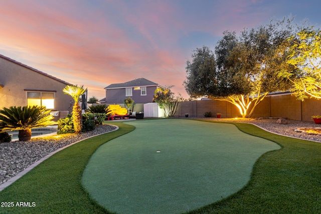 fenced backyard featuring a putting area