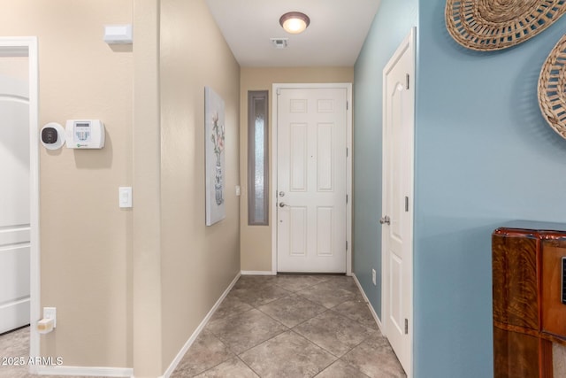 entryway with baseboards and light tile patterned flooring