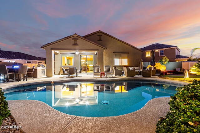 pool at dusk with an outdoor hangout area, a patio, and outdoor dining area