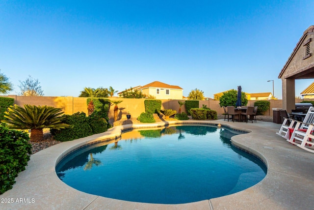 view of pool with a patio area, a fenced backyard, and outdoor dining space