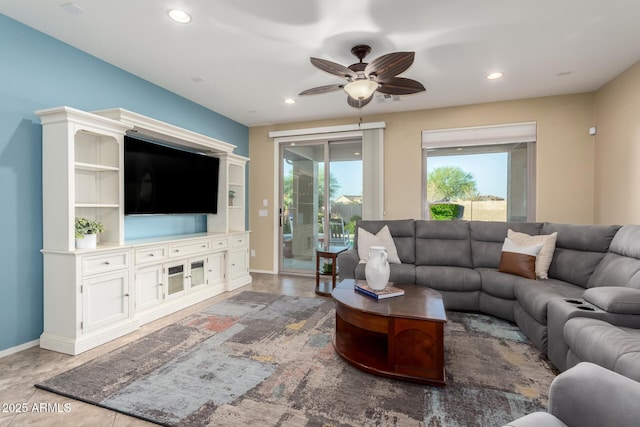 living area with recessed lighting, a ceiling fan, and baseboards