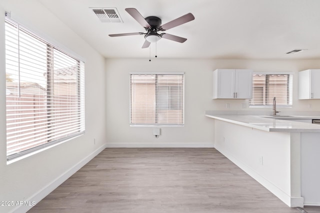 kitchen featuring sink, plenty of natural light, white cabinets, and light wood-type flooring