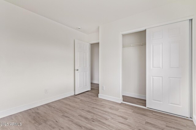 unfurnished bedroom featuring a closet and light wood-type flooring