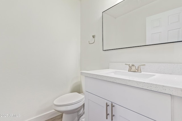 bathroom featuring hardwood / wood-style flooring, vanity, and toilet