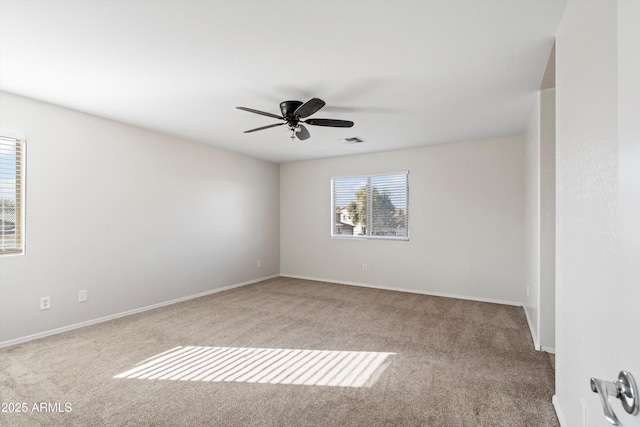 carpeted spare room with ceiling fan