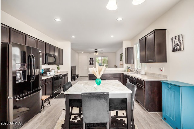17573 W Via De Luna Dr, Surprise, AZ 85387 - kitchen featuring black appliances, dark brown cabinets, light wood-style flooring, and recessed lighting
